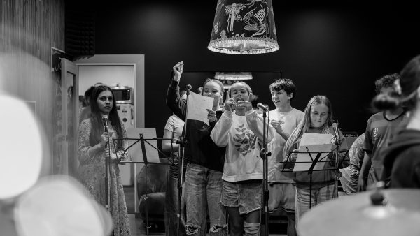 Group of young people singing into a microphone in a b & w ohoto