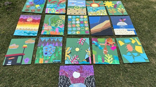 colourful artwork painted on squares lined up on grass